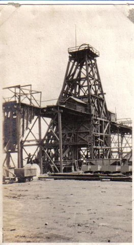 A black-and-white photograph of a wooden mine headframe and shaft house near Ironton on the Cuyuna Range, with an ore car on narrow-gauge rail in the foreground